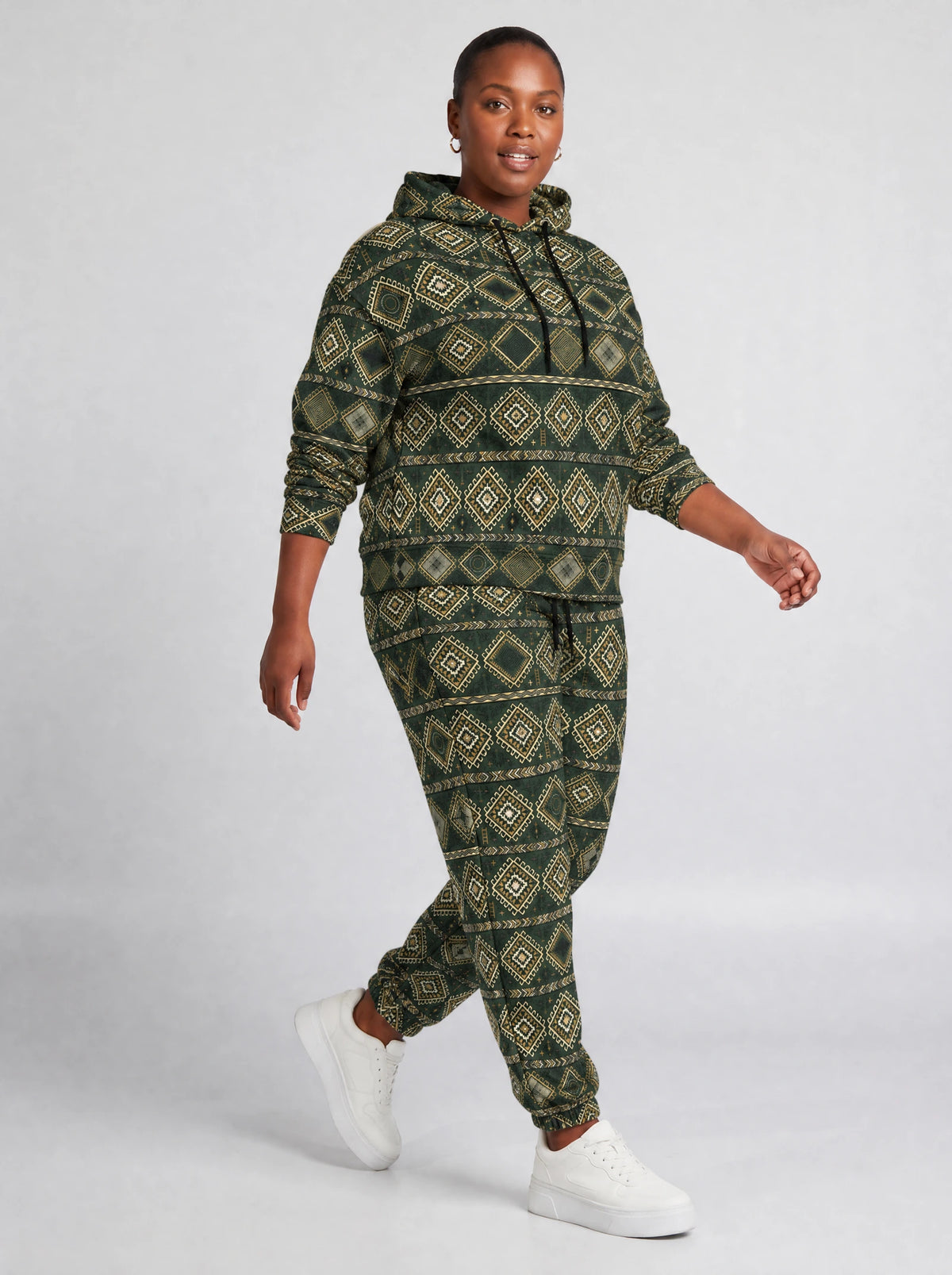 "Kilele" Forest Brass Hoodie & Jogger Set — walking three-quarter view on model