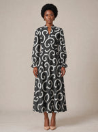 "Duara" Long Puff Sleeve Dress — standing, angled view on model