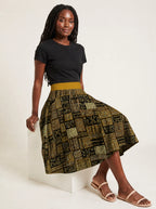 "Sankofa" Twirl Skirt — seated on a studio cube