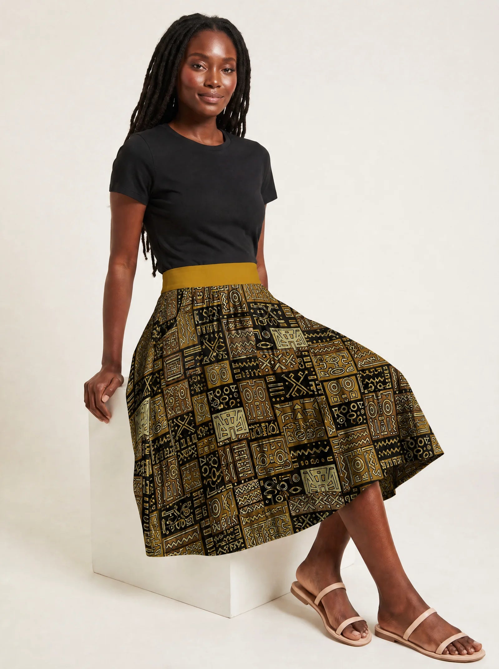 "Sankofa" Twirl Skirt — seated on a studio cube