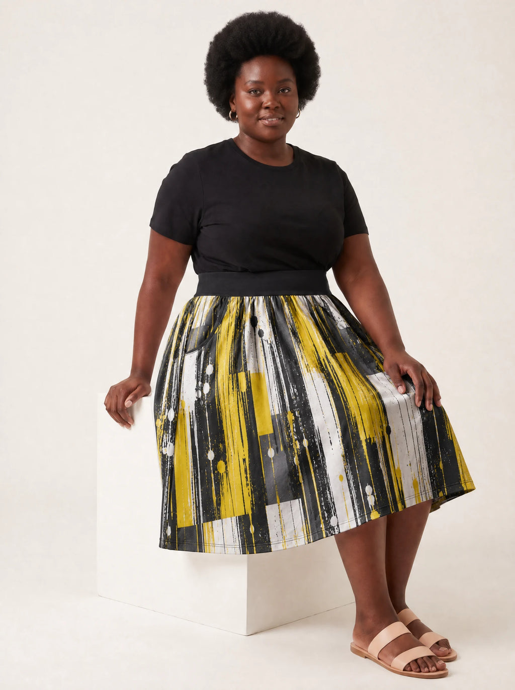 "Mvua" Twirl Skirt — seated on a studio cube