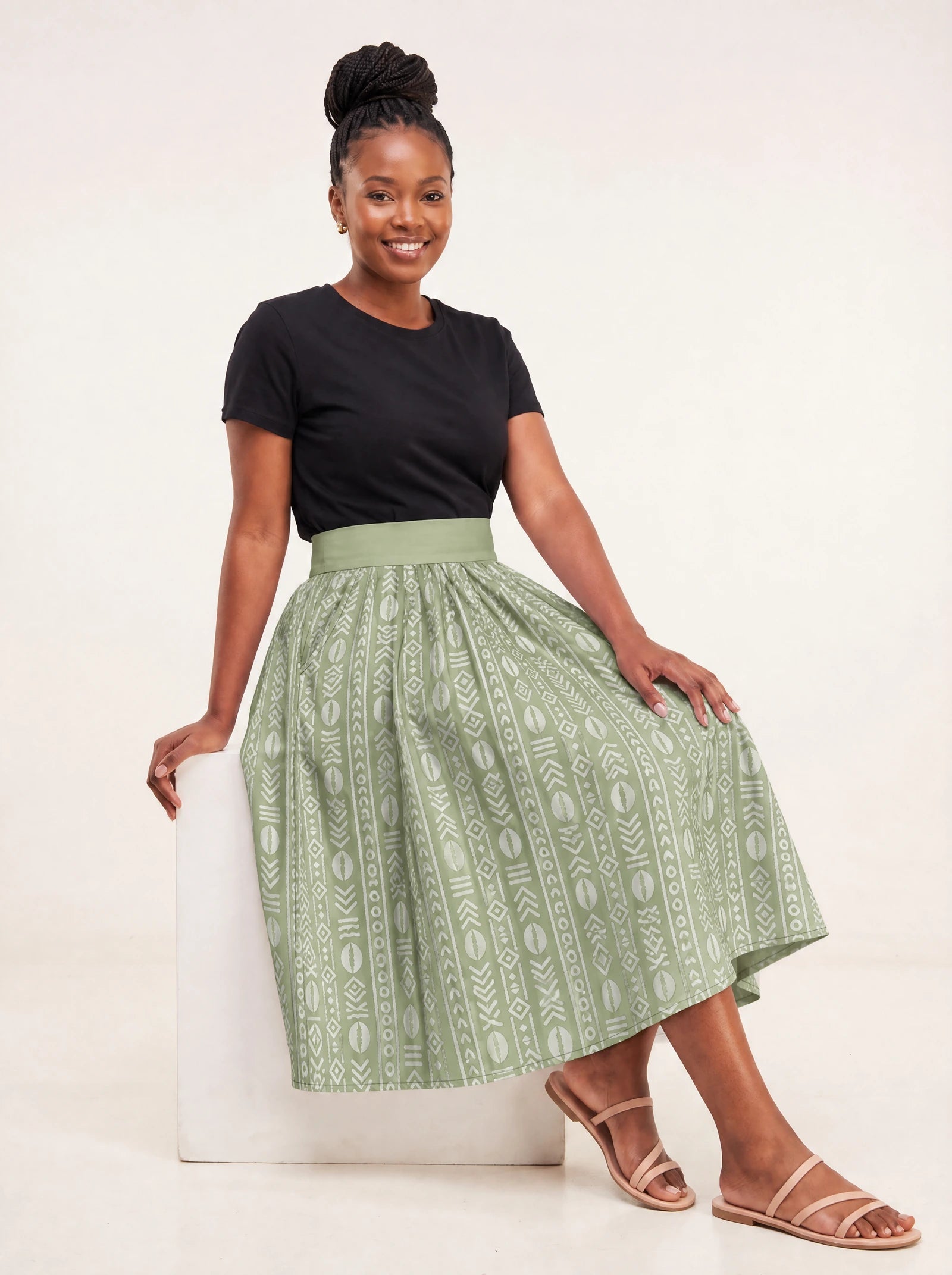 "Oshun Verde" Twirl Skirt — seated on a studio cube
