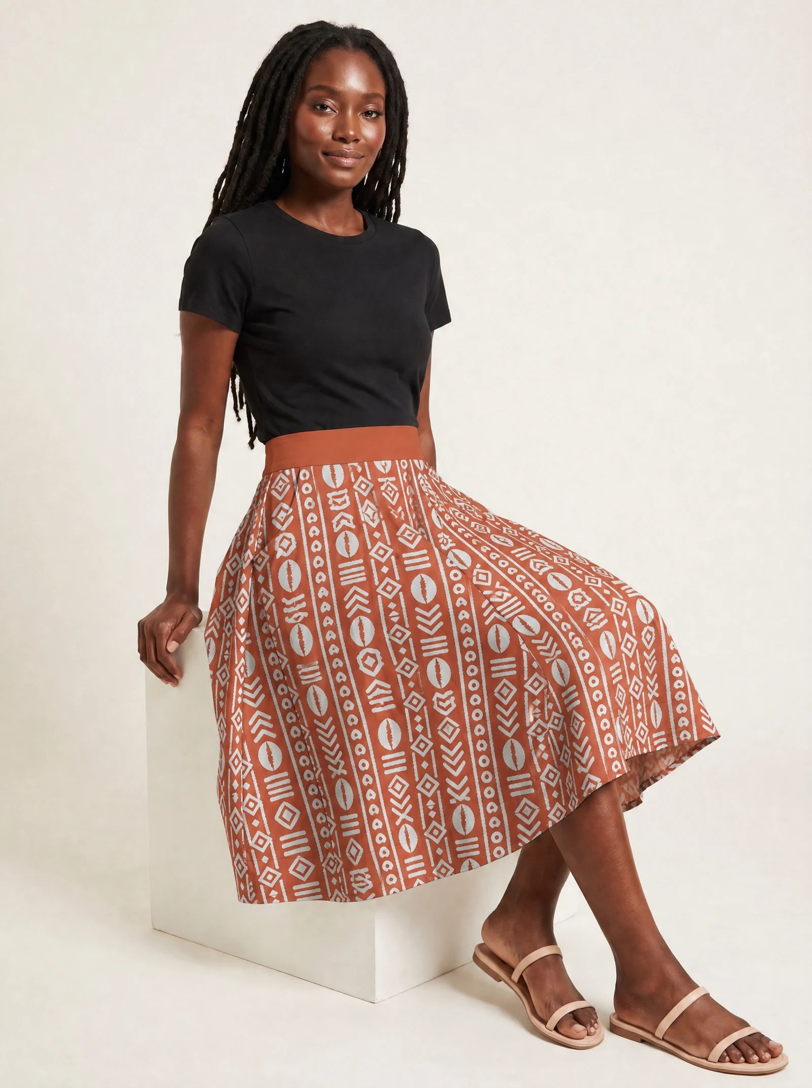 "Oshun Kijani" Twirl Skirt — seated on a studio cube
