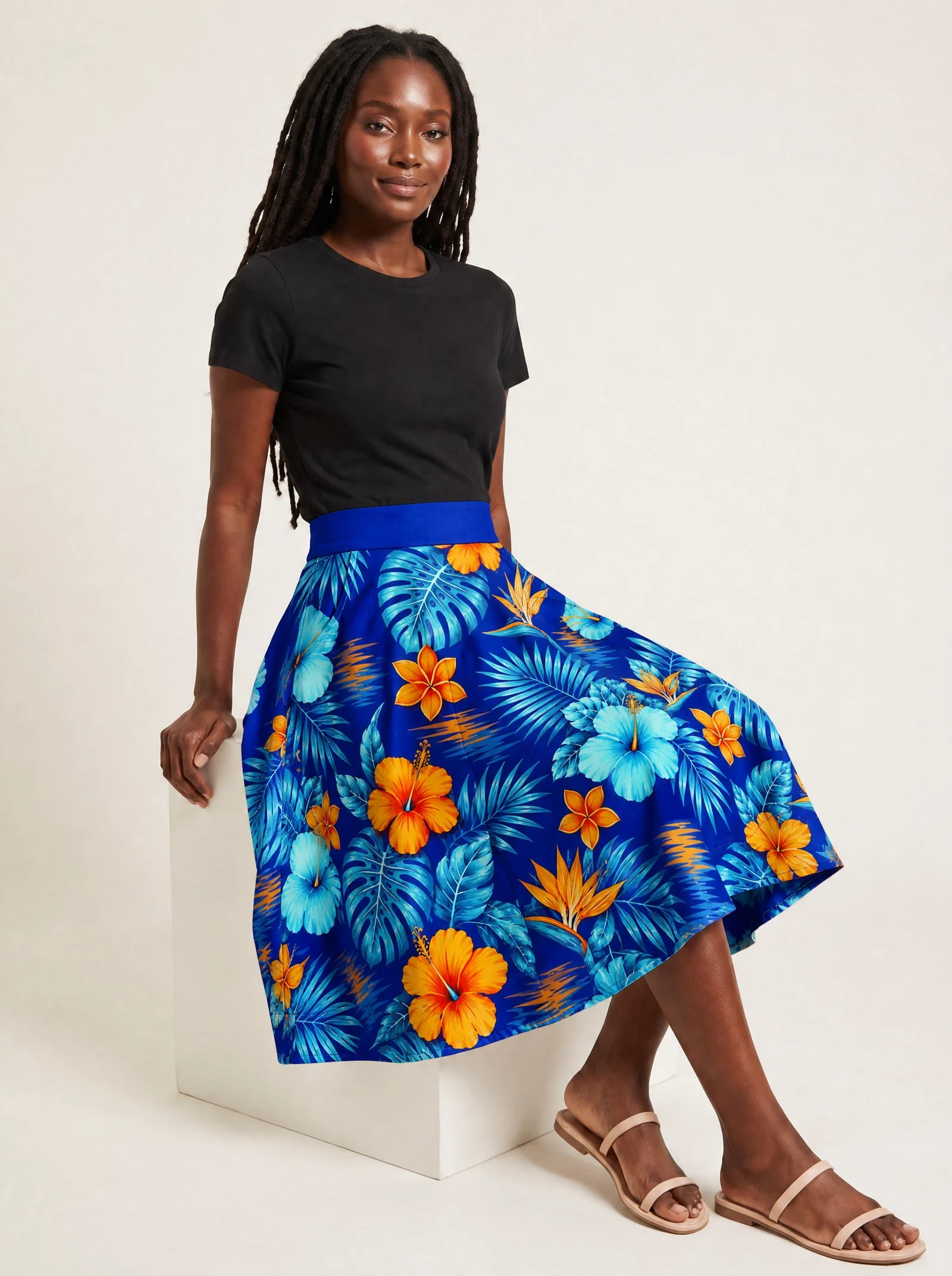 "Maua" Twirl Skirt — seated on a studio cube