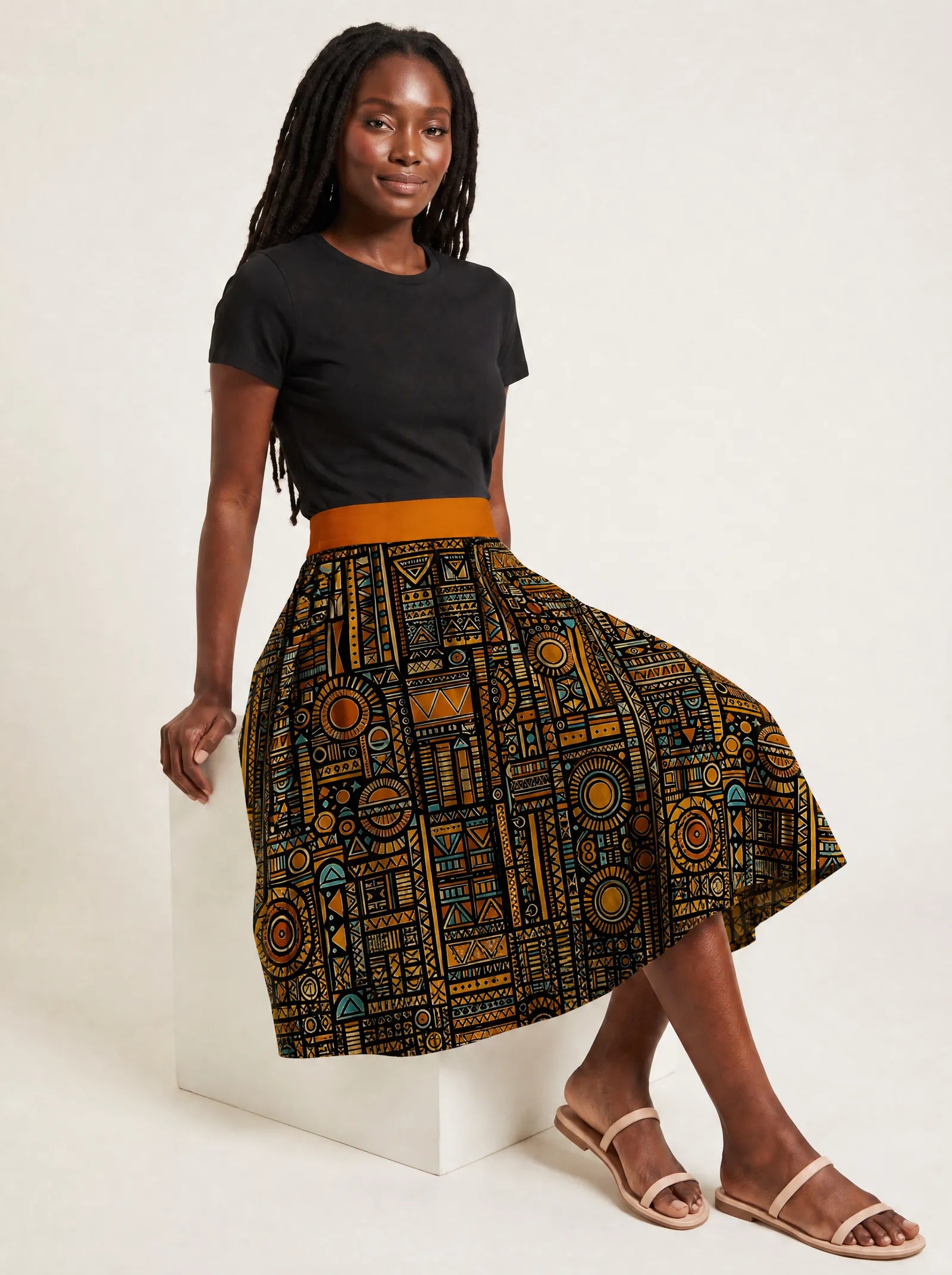 "Afrocentric Pattern" Twirl Skirt — seated on a studio cube