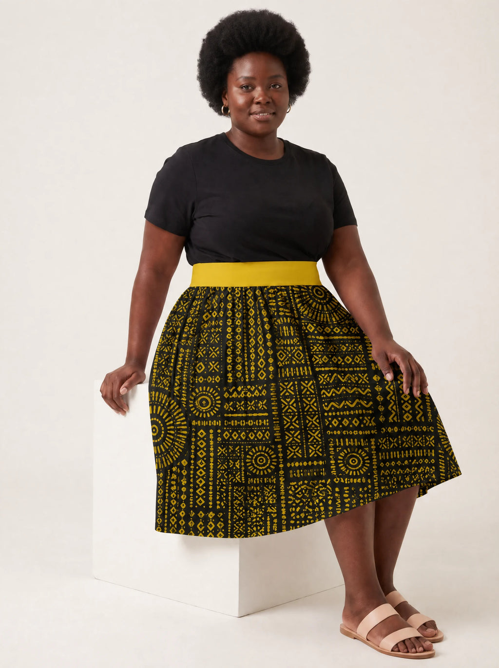 "Lamu" Twirl Skirt — seated on a studio cube
