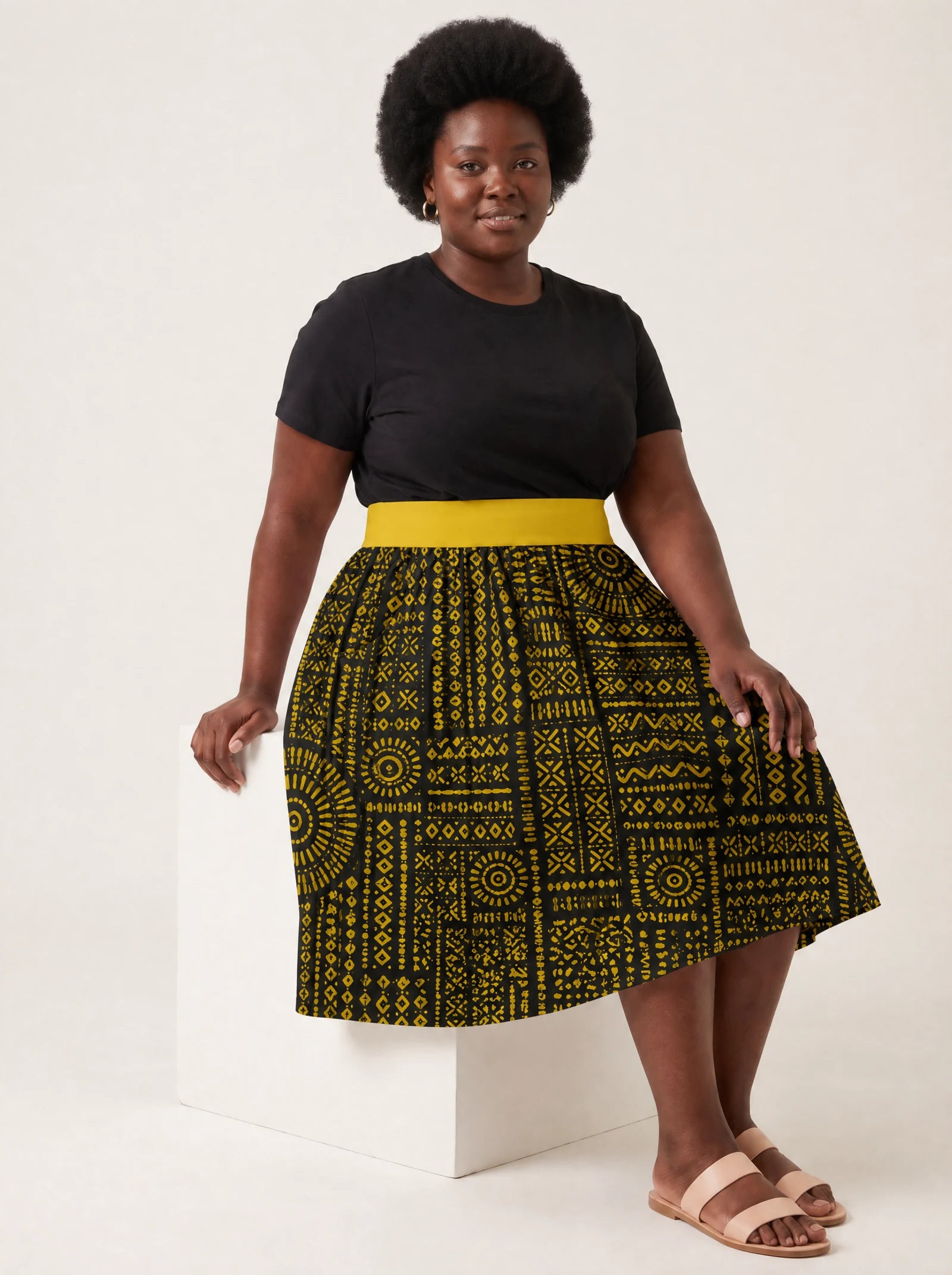 "Lamu" Twirl Skirt — seated on a studio cube