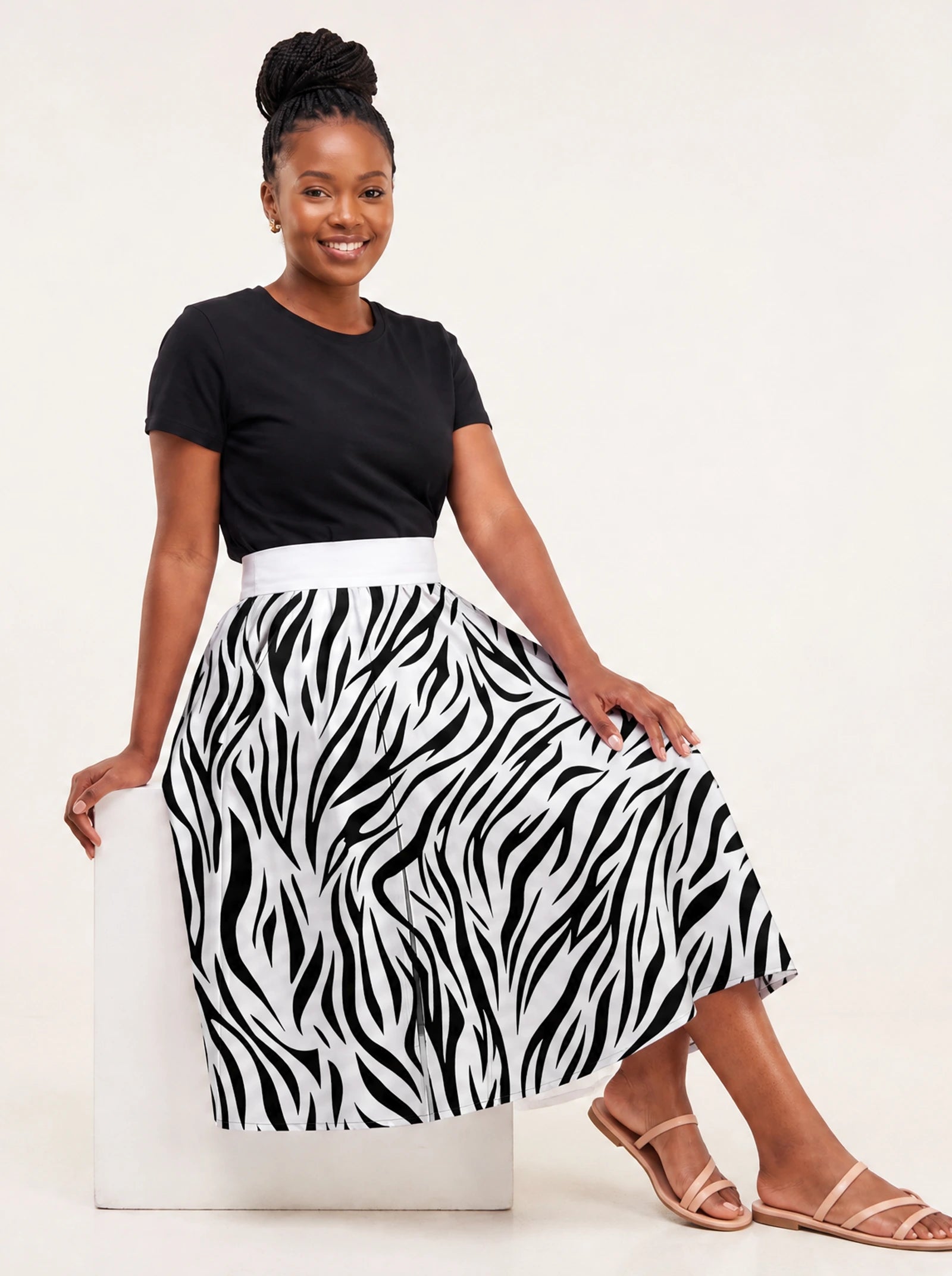 "Milia" Twirl Skirt — seated on a studio cube