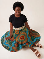 "Mto" Twirl Skirt — seated on the floor with the skirt fanned out