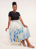 "Samaki" Twirl Skirt — seated on a studio cube