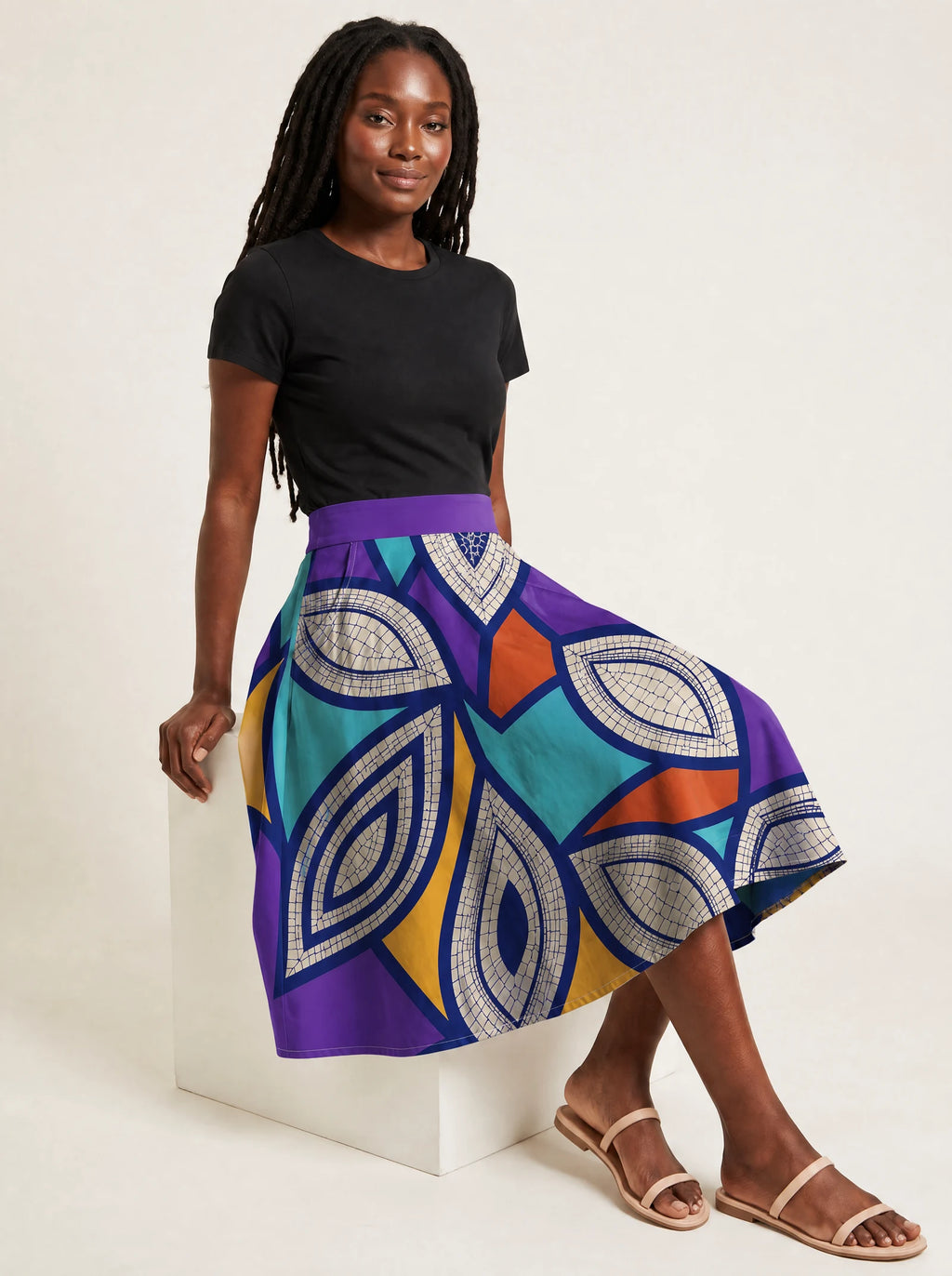 "Johari" Twirl Skirt — seated on a studio cube