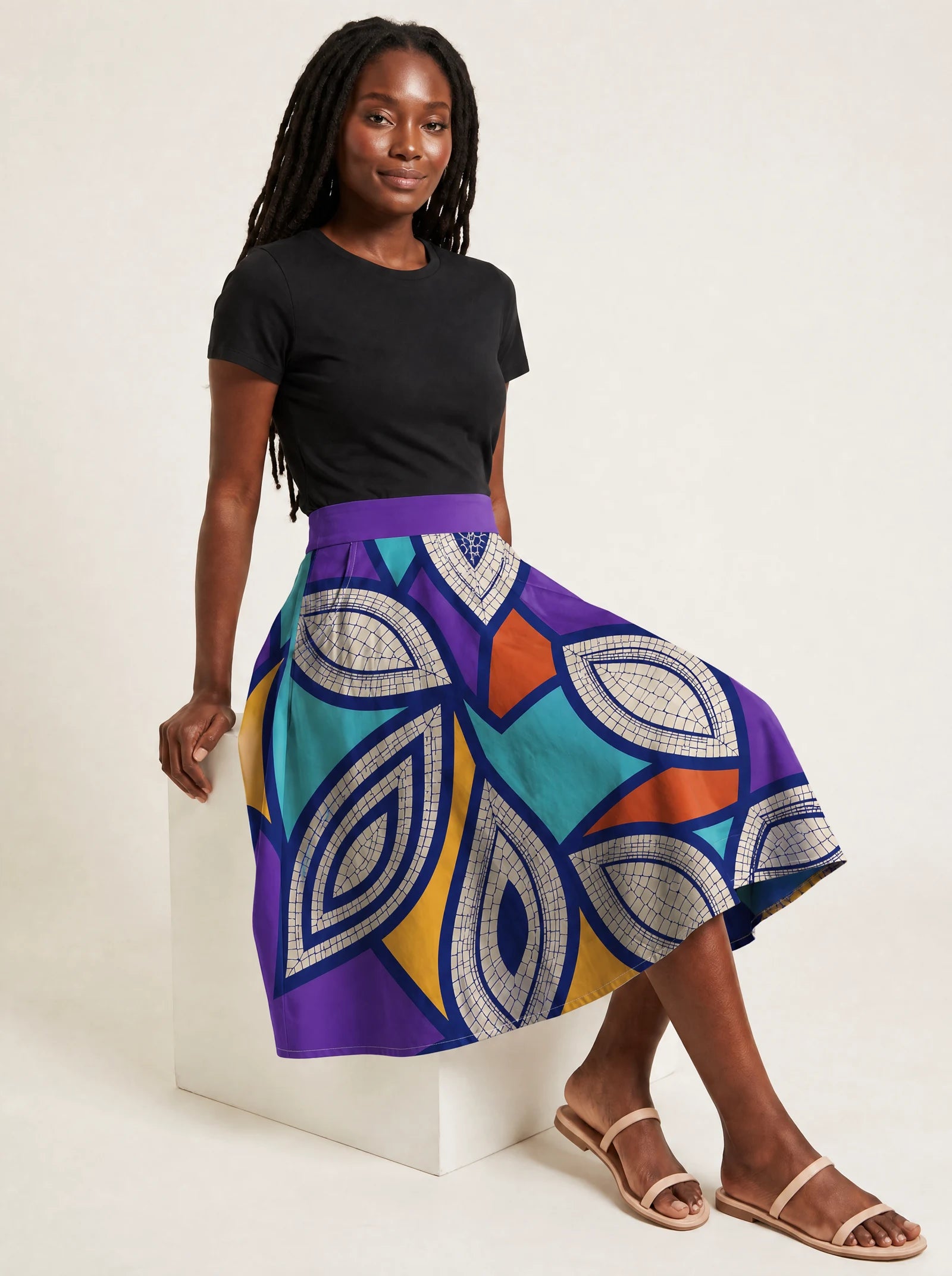 "Johari" Twirl Skirt — seated on a studio cube