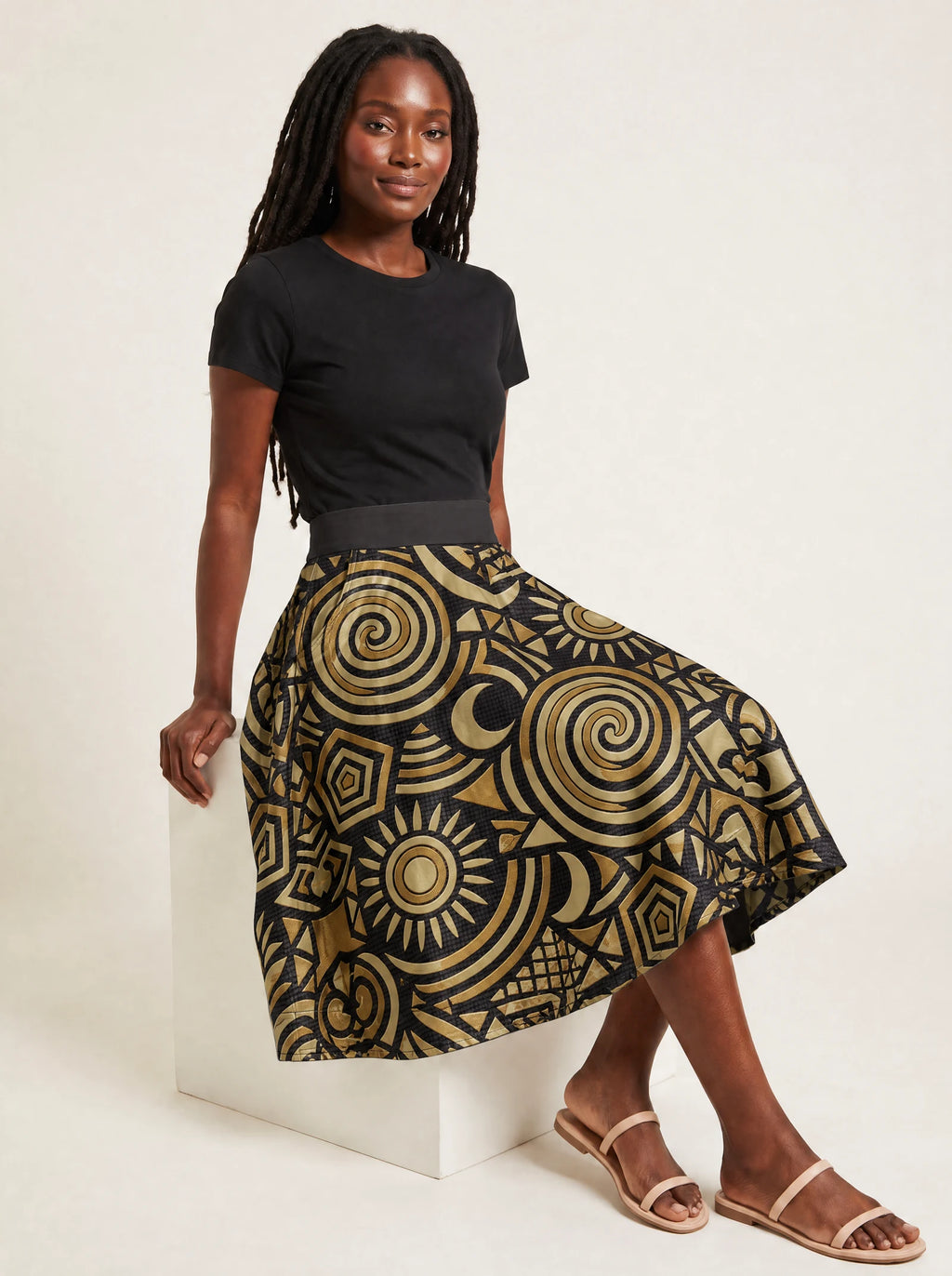 "Sahara" Twirl Skirt — seated on a studio cube