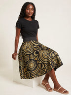 "Sahara" Twirl Skirt — seated on a studio cube