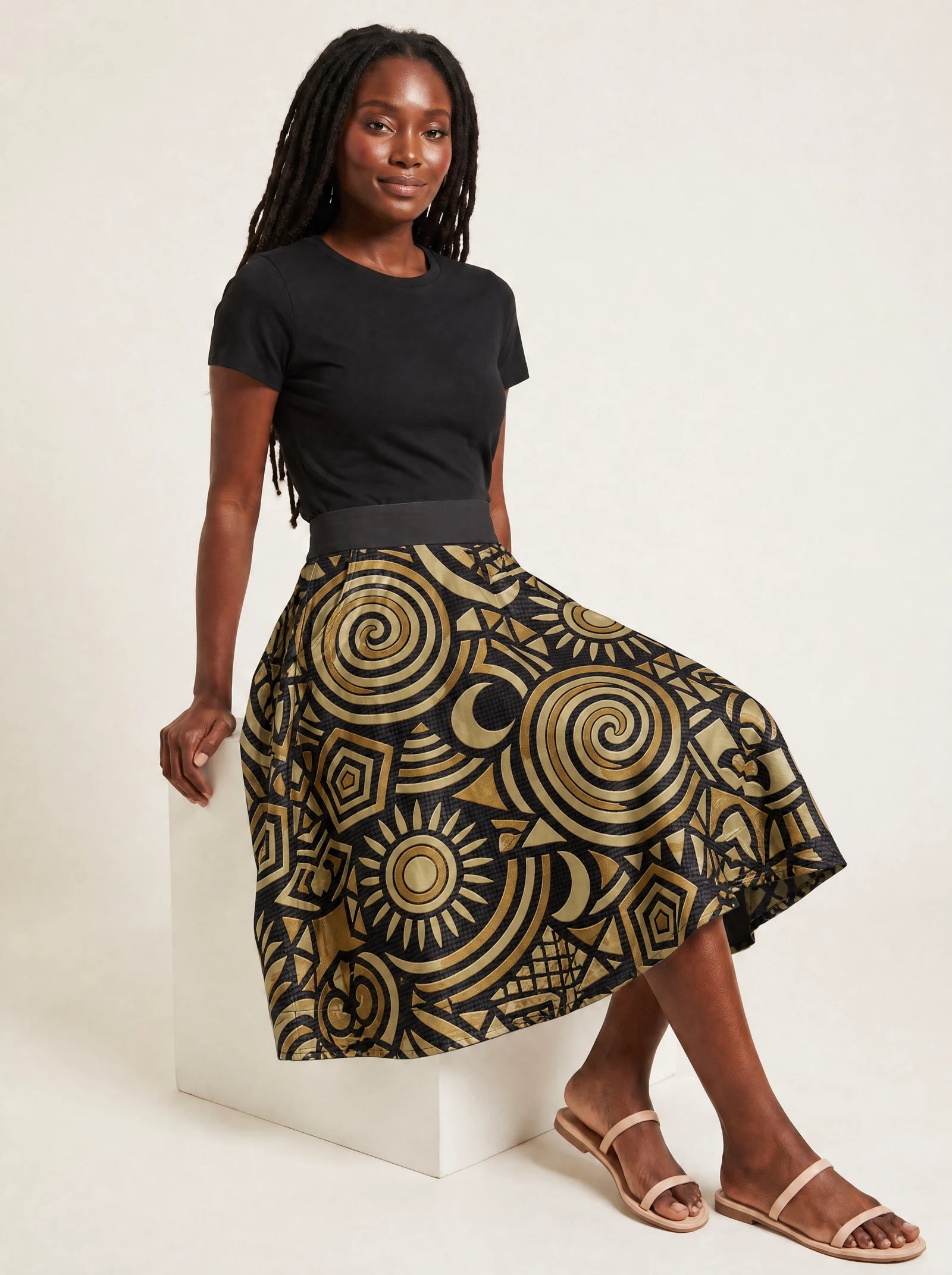 "Sahara" Twirl Skirt — seated on a studio cube