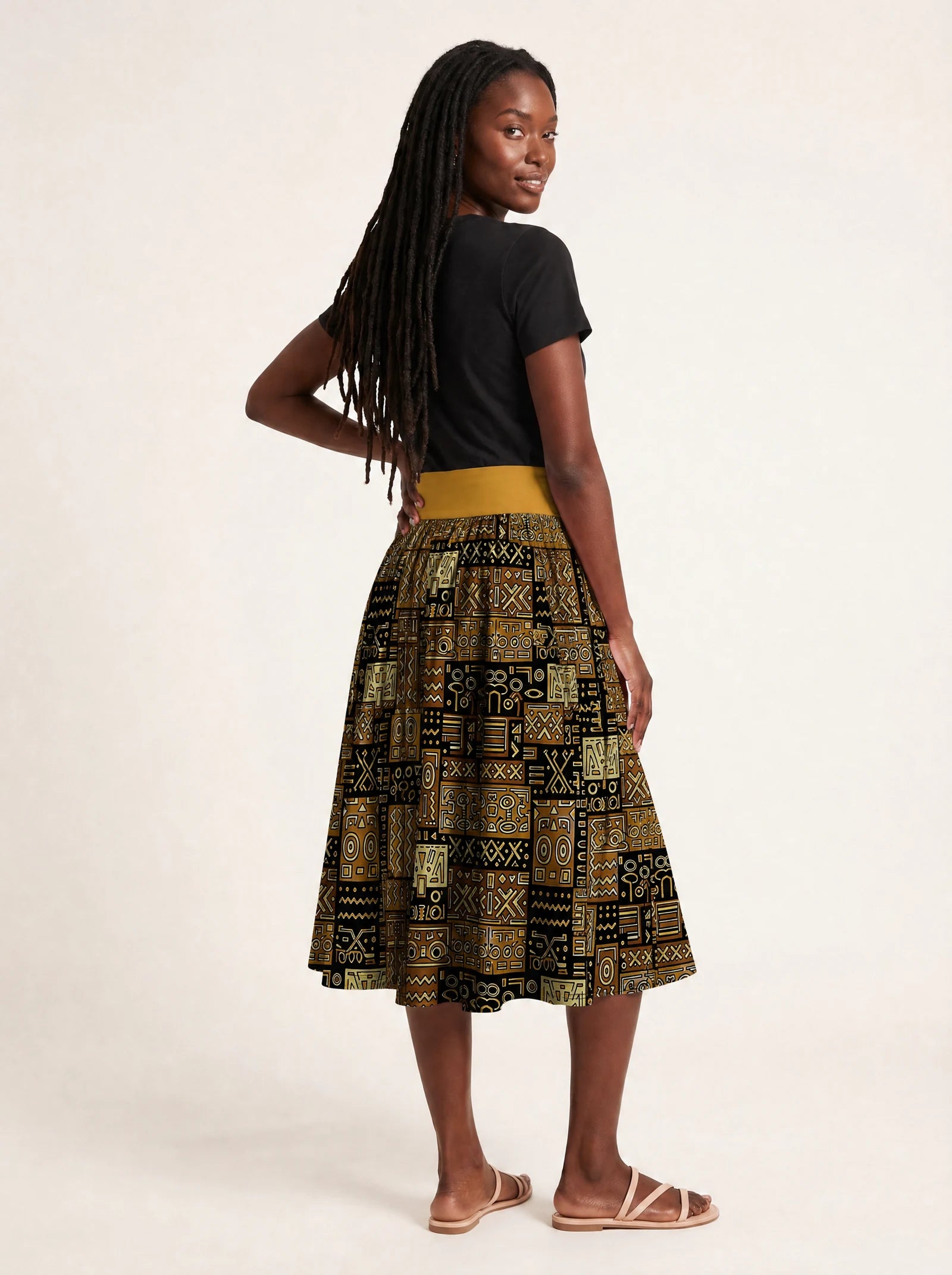 "Sankofa" Twirl Skirt — back three-quarter view, looking over shoulder